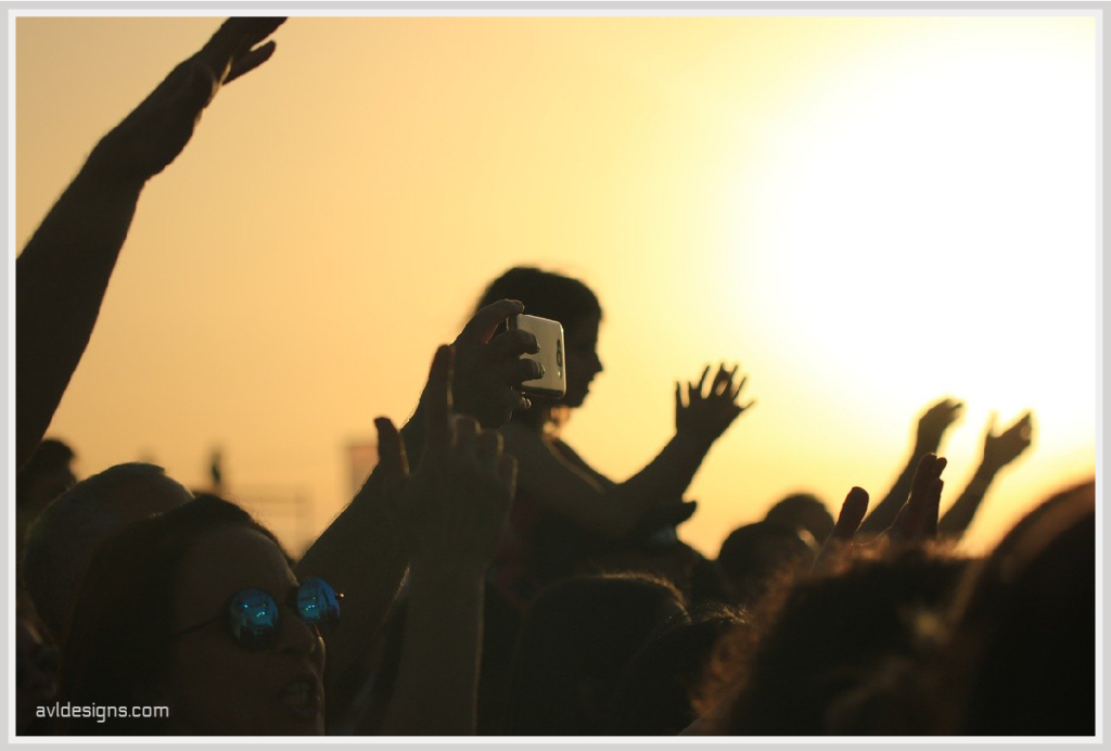 people in a concert audience, clapping. 